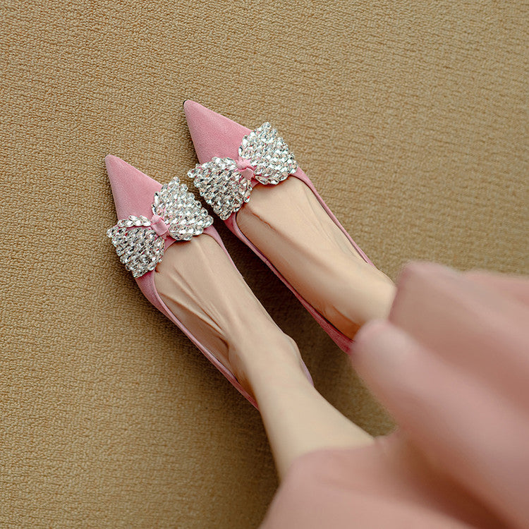 Pink high-heeled shoes with silver bow decorations on a beige background