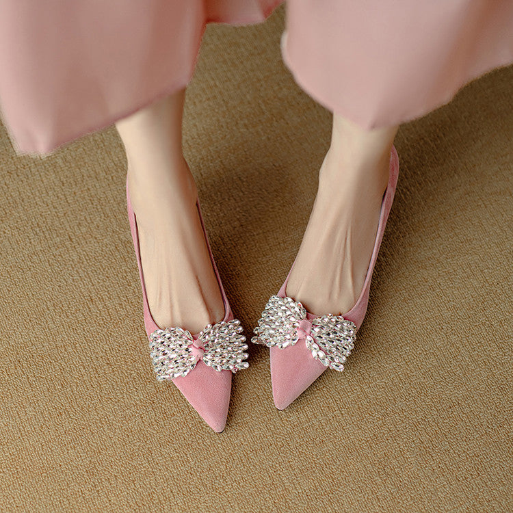 Pink high-heeled shoes with decorative bows on a beige carpet