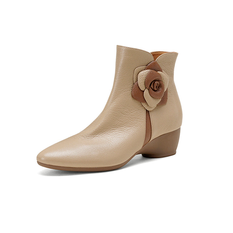 Beige ankle boot with a brown flower detail on a white background,side view.