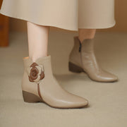 Beige ankle boots with a floral design on a neutral background