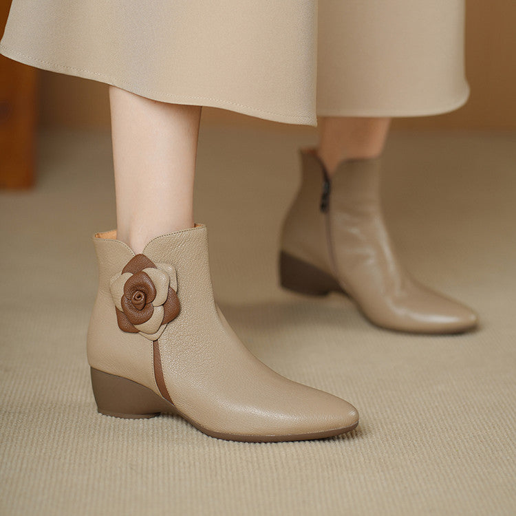 Beige ankle boots with a floral design on a neutral background