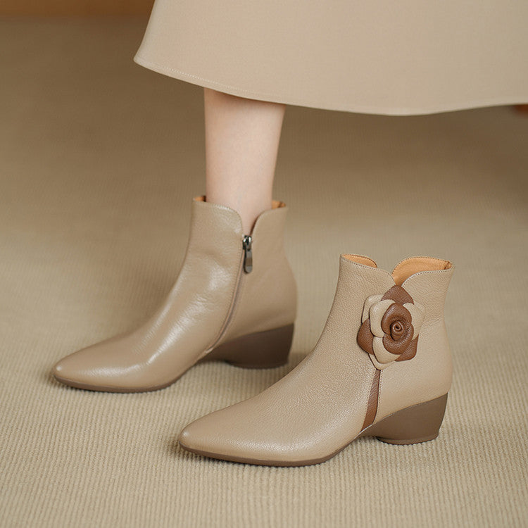 Beige ankle boots with a floral design on a beige background
