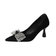 Black high-heeled shoe with a decorative bow on a white background