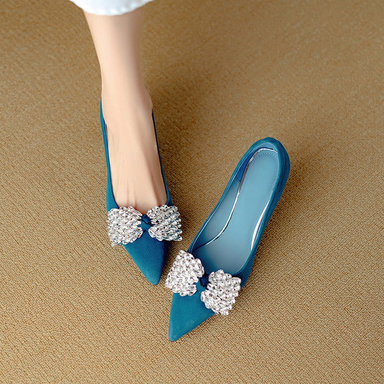 Blue high-heeled shoes with decorative elements on a beige surface