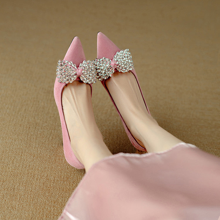 Pink high-heeled shoes with decorative bows on a beige background