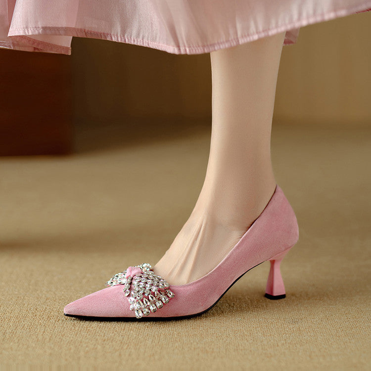 Pink high-heeled shoes with a decorative bow on a beige background
