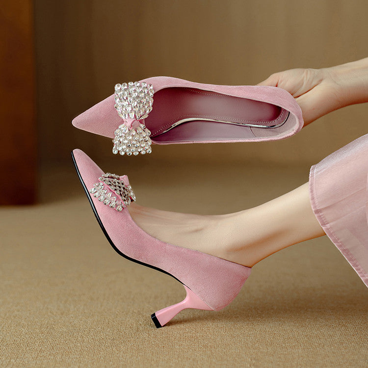 Pink high-heeled shoes with decorative bows on a beige background