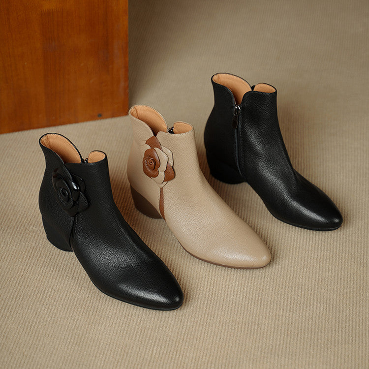  ankle boots in black, beige, and brown on a textured surface.