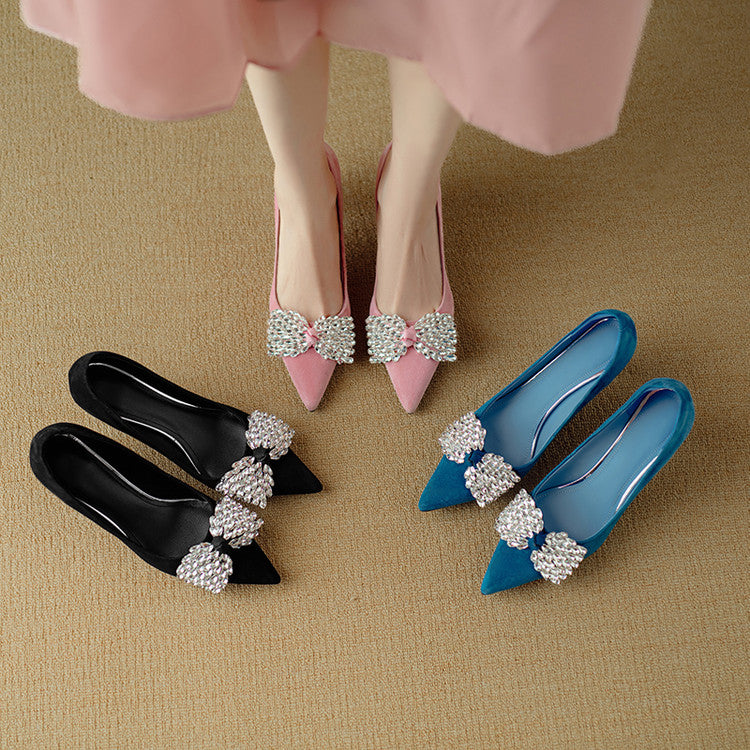 Pink high heels with decorative bows on a beige surface